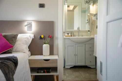 科尔托纳Locanda agli Amici的一间卧室配有床、水槽和镜子