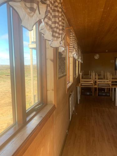 BergsstaðirGíslaskáli的带窗户的房间和带桌子的用餐室