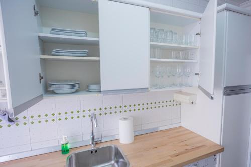 马拉加Apartamento Parque Mediterráneo的厨房配有白色橱柜和水槽