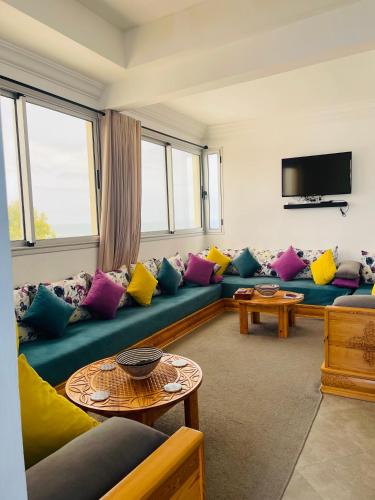 沃利迪耶Chez abdelilah的客厅配有蓝色沙发及色彩缤纷的枕头