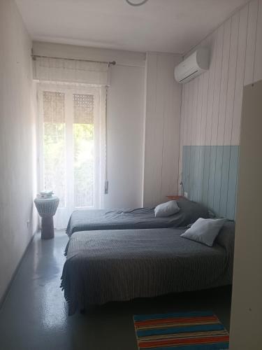 维亚雷焦appartamento vale的一间卧室设有两张床和窗户。