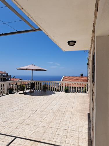 斯韦蒂·斯特凡德拉吉斯科公寓式酒店的一个带遮阳伞的庭院和背景海洋