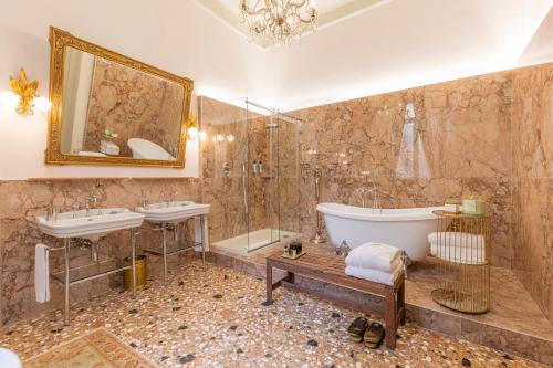 维罗纳Corte Realdi - Palazzo Camozzini的大型浴室设有2个水槽、浴缸和浴缸。