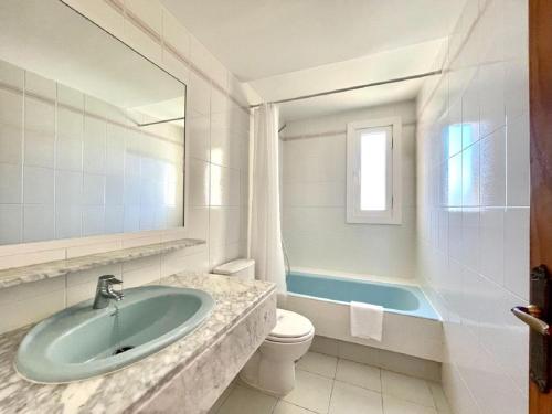 滨海罗克塔斯Beachfront apartment in Roquetas de Mar with communal pool的浴室配有盥洗盆、卫生间和浴缸。