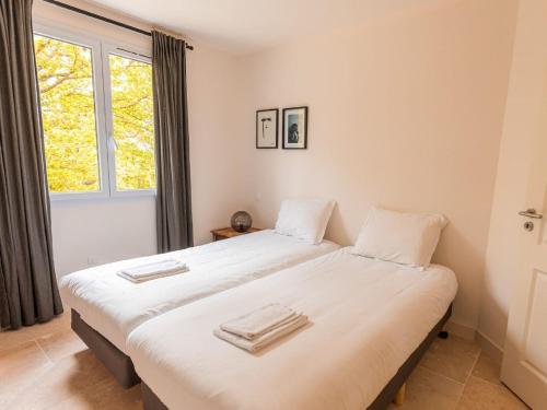Les ForgesSpacious and modern villa with large garden and BBQ area的带窗户的客房内设有两张单人床。