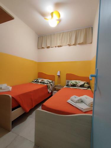 丽都玛里尼La casa di Stefy的黄色和白色墙壁的客房内的两张床
