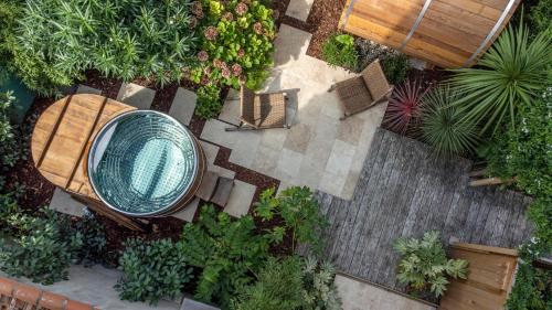 拉罗谢尔Escale Rochelaise, gîte urbain avec SPA bain nordique et sauna tonneau的享有花园的顶部景致,设有长凳和椅子
