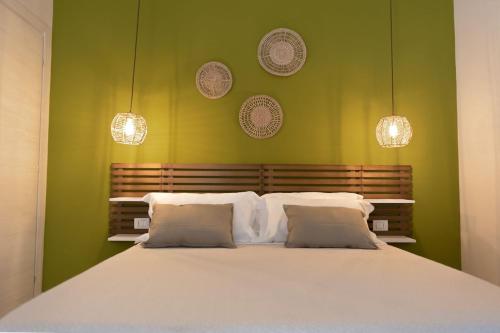 波萨达Sunrise Sardinia Posada的卧室配有白色大床和绿色墙壁
