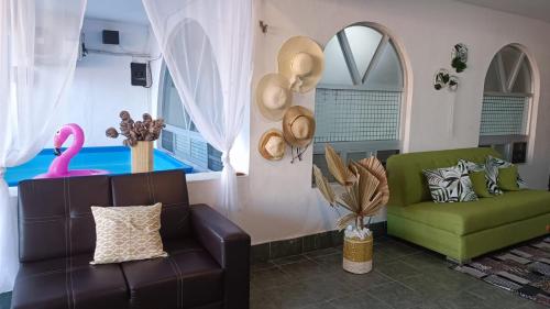 坎昆Casa Calis Cancún的客厅配有沙发和粉红色椅子