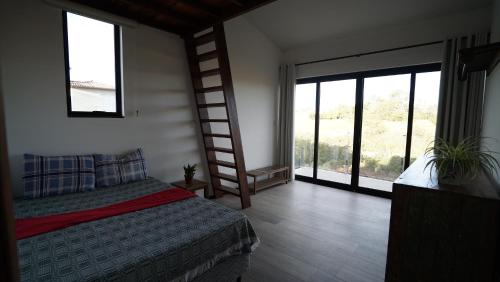 迪亚曼蒂纳Casa do Sol的一间卧室设有一张床、梯子和窗户