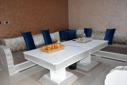 El BiarGhazalle Oasis Hotel 1的白色的桌子和带蓝色枕头的沙发
