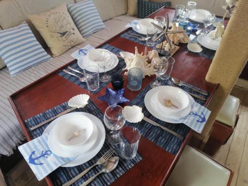 苏利纳Corabia Santa Marina的一张木桌,上面有盘子和玻璃杯