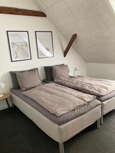 瓦尔德Varde Bed and Kitchen的卧室内的一张大床,墙上有两张照片