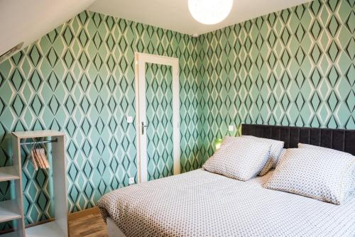MondrepuisGîte Version 70的一间卧室设有一张床和绿色的墙壁