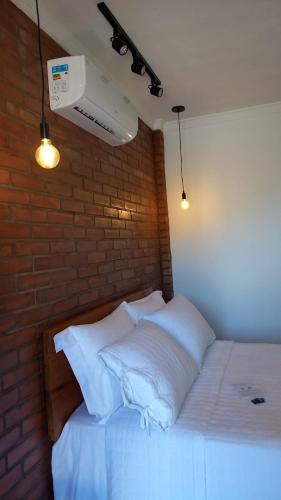 诺布里斯Pousada Bem Viver的卧室配有白色的砖墙床