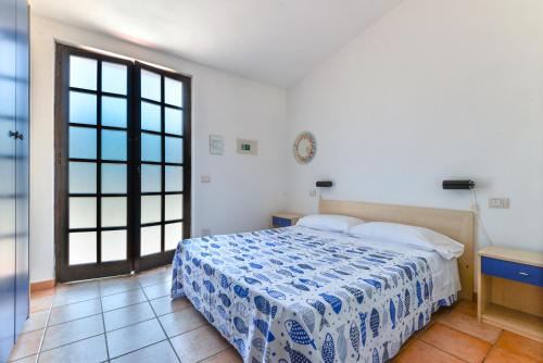 卡波利韦里Residenza Elbamare的一间卧室配有一张带蓝白色毯子的床