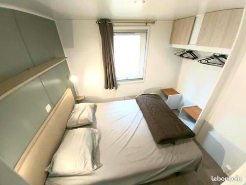 拉戈尔斯Mobil home climatisé 6pers. 3CH camping domaine de chaussy 5* Ardèche的小房间设有一张带窗户的床