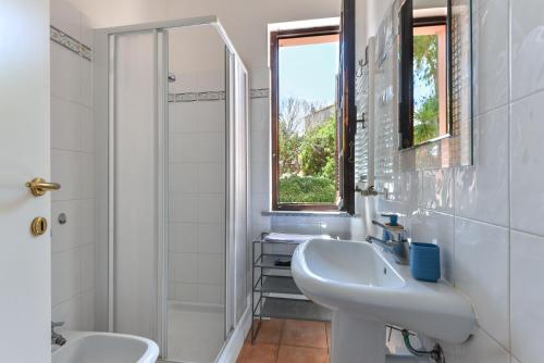 卡波利韦里Residenza Elbamare的白色的浴室设有水槽和淋浴。