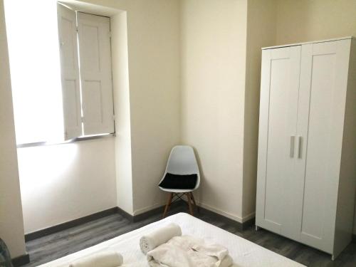 马亚Cantinho da Karine的卧室配有床、椅子和窗户。