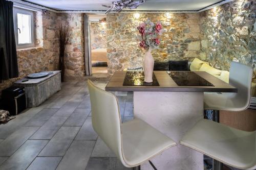 雅典Stone House的一间带桌子和白色椅子的用餐室