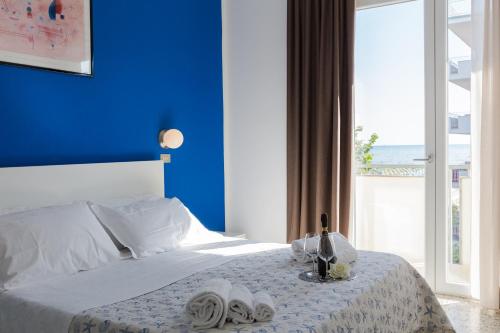 里米尼圣雷莫酒店的蓝色的卧室,配有一张蓝色墙壁的床