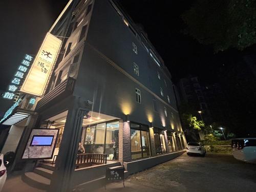 礁溪沐-湯宿溫泉行旅的一座建筑物,晚上在建筑物的一侧有标志