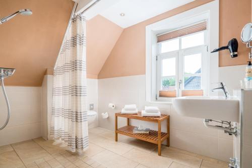 戈斯拉尔施韦柯什豪斯GDA公寓式酒店的带淋浴和盥洗盆的浴室以及窗户。