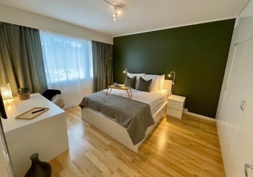 科特卡Hogland Apartments - 2的一间卧室设有一张床和绿色的墙壁