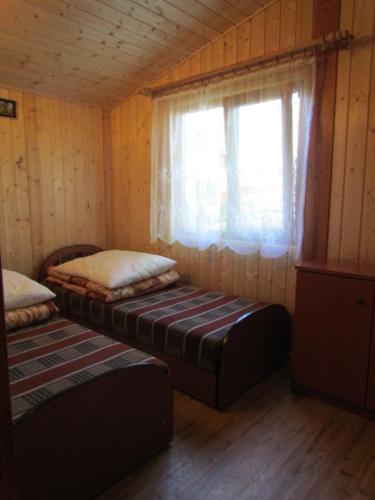 梅尔诺OW ZŁOTA PLAŻA的一间设有两张床的房间和一个位于小屋的窗户