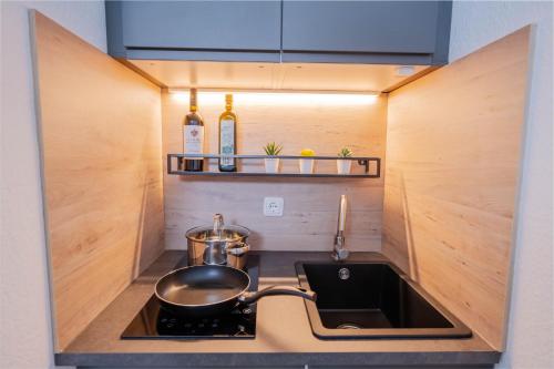 伍珀塔尔Apartments an der Universität的厨房配有水槽和炉灶上的锅