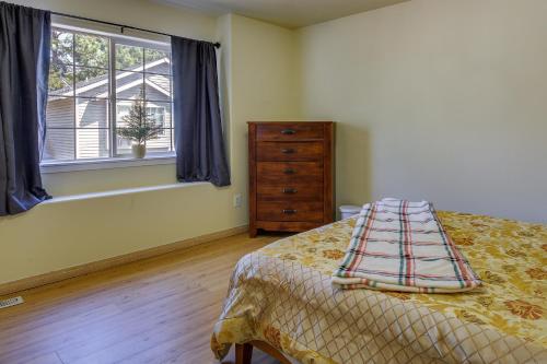 波特兰Portland Vacation Rental with Fireplace - Near Parks的一间卧室配有一张床、一个梳妆台和一扇窗户。