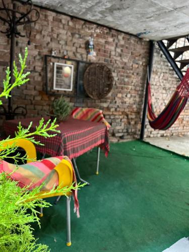 第比利斯Hostel Nomad的一个带桌椅和砖墙的庭院
