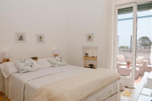 卡普里Casa Rubina的白色的卧室设有床和大窗户