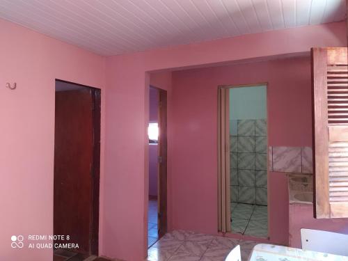 卡诺格布拉达Suítes D'Belinha的一间设有粉红色墙壁和玻璃门的房间
