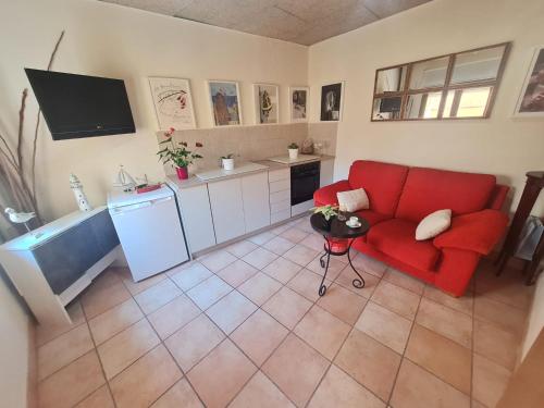 帕拉莫斯DUNA Y DANA的一间带红色沙发的客厅和一间厨房