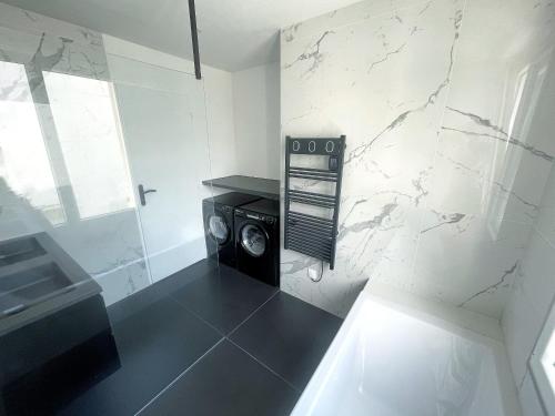 拉罗谢尔Les appartements du Carnot - Terrasses et Jardins的客房内的洗衣机浴室