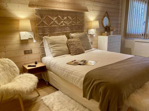 Les FourgsNOTRE CHALET - Boutique Hôtel - En couple - En famille - En groupe的一间卧室配有一张大床和一把椅子