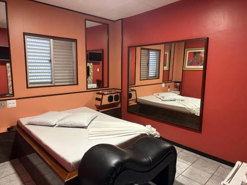 贝洛奥里藏特Motel Cigano’s的一间卧室配有一张床和镜子