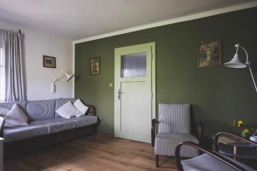 HrádekChaloupka Na Gruni的客厅设有灰色的沙发和门。