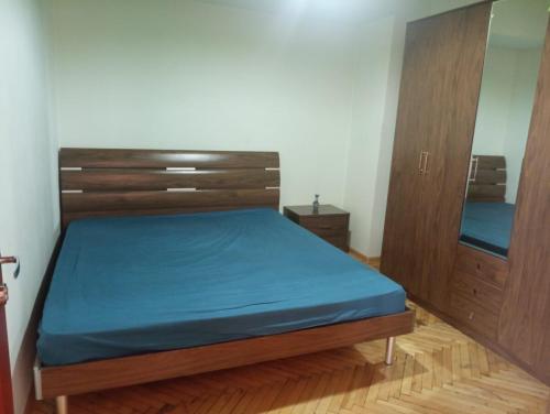 埃里温City Center Cozy Apartment Tigran Mets的一间卧室配有一张床和两个木制橱柜。