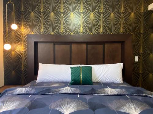 佩尼亚斯科港Ancla Suite 9 - Urban Hotel的一间卧室配有一张带绿色和白色枕头的床