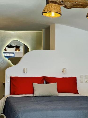 ProvatasCave Beach House Milos的一间卧室配有红色和蓝色床单