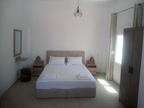 巴特斯欧AMPELOS ANDROS的卧室配有白色的床和窗户。