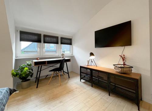 门兴格拉德巴赫Komfortable und gemütliche Wohnung mit 2 SZ的客厅配有书桌和墙上的电脑