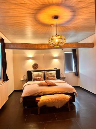 迪尔森-斯托科姆‘t Vaerthuys的一间卧室设有一张带木制天花板的大床