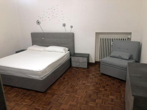诺瓦拉Appartamento Lore的一间卧室配有一张床和一把椅子