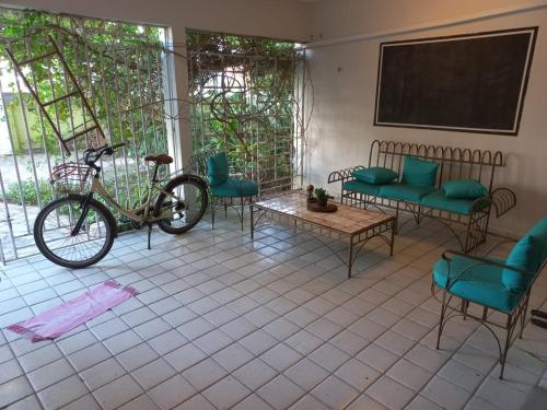 若昂佩索阿Pousada jardim de cabo branco的停放在带椅子和黑板的房间的自行车
