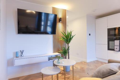珀斯Luxurious City Centre Apartment的客厅配有沙发和墙上的电视