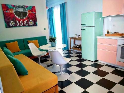 纳克索乔拉Nostalgia Retro Suites的带沙发和桌子的客厅以及厨房。