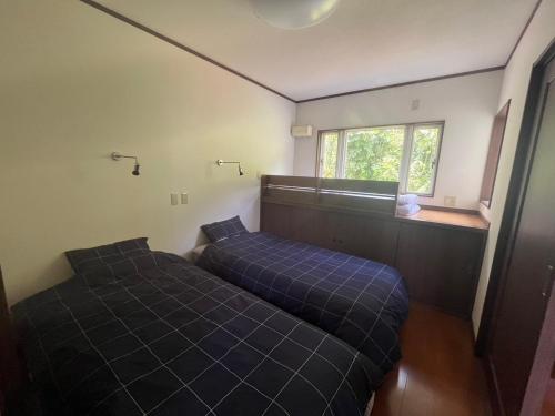Kogushiゼロベース下関室津的一间卧室设有两张床和窗户。